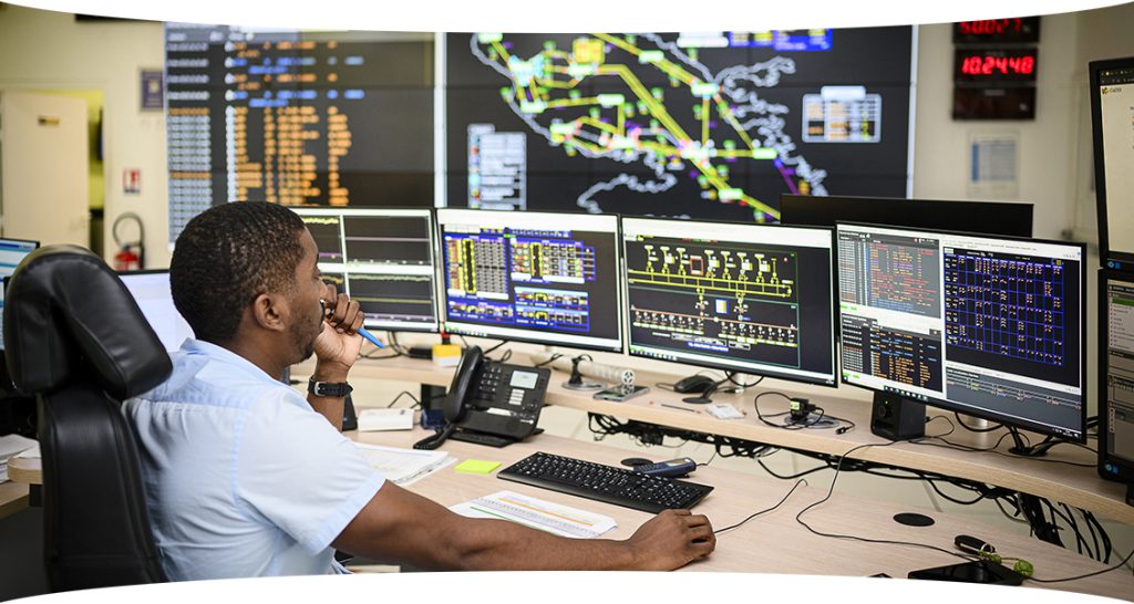 Opérateur supervisant depuis une salle de contrôle le dispatch et la régulation de l'électricité produite par les barrages et stations de pompage-turbinage